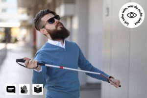 Eine Person, Männlich, mit Bart, Sonnenbrille, Blindenstock in den Händen, Auf dem Fußgängerweg