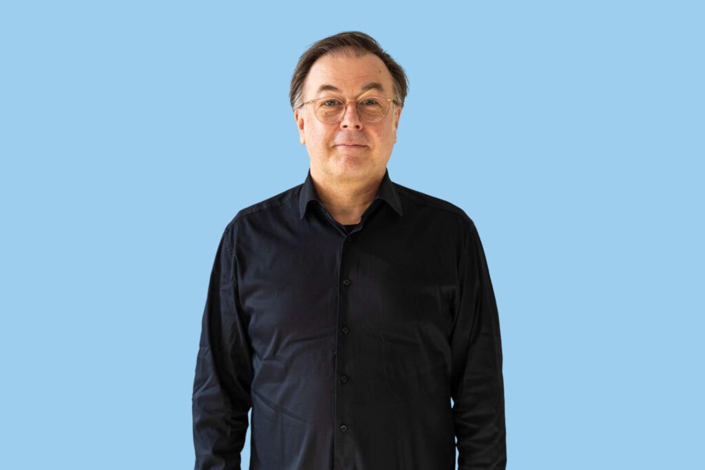 weißer Mann mit schwarzem Hemd und Brille