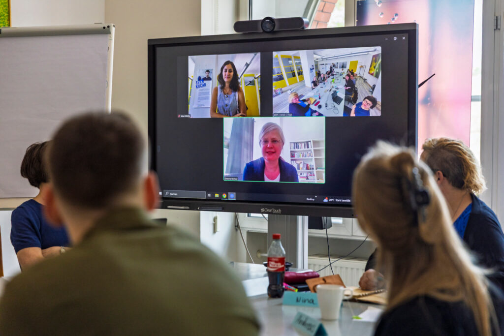 Blick auf einen Screen mit 3 Personen in Video-Fenstern.