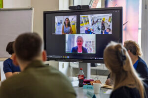 Blick auf einen Screen mit 3 Personen in Video-Fenstern.